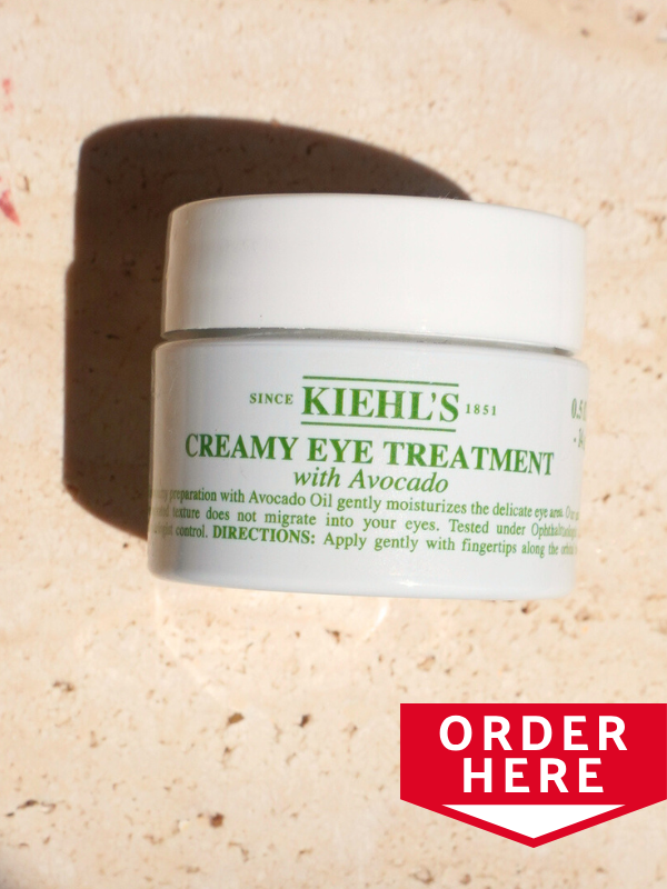 Kiehl's avocado eye cream jar on travertine table top