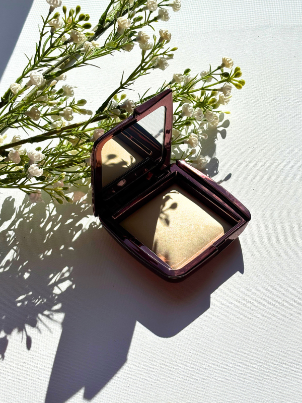 finishing powder hourglass ambient lighting pot open on canvas
